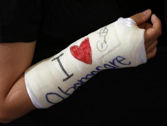 Cathey Park shows her cast signed by U.S. President Obama after he spoke about health insurance at Faneuil Hall in Boston